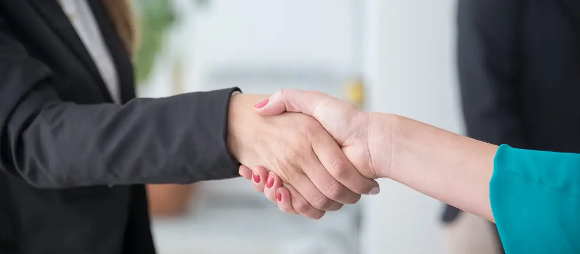 Real estate agent and client shaking hands after successful property valuation